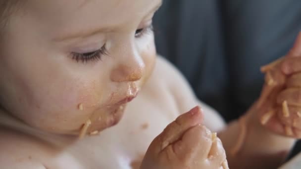 Video with a little baby girl eating her dinner and making a mess. Baby eating mess, great design for any purposes. Head shot. — Video