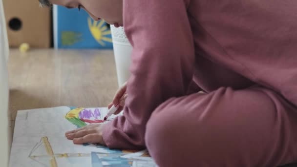 Vidéo. Garçon caucasien appréciant le dessin assis sur le sol. Développement de l'enfant. — Video
