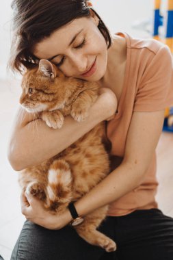 Gülümseyen kadın kedisine sarılıyor. Yakın plan portre. Kediyi kucaklayan kadın, her amaç için harika bir tasarım..