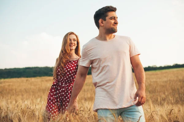 Framifrån av ett par som håller händer och går i vetefält. Vetefält. Hålla handen. — Stockfoto