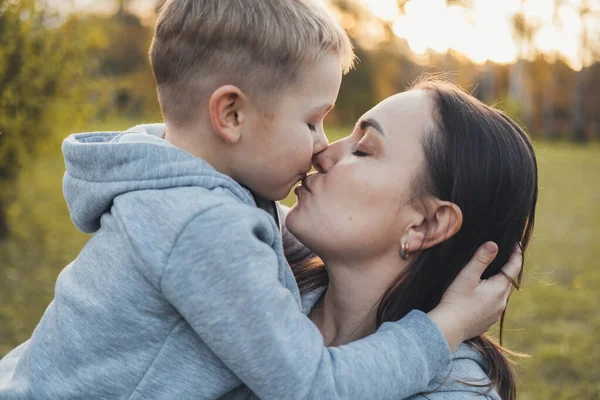 Κοντινό πορτραίτο ενός αγοριού που φιλούσε τη μητέρα του έξω. Εξωτερικό πορτρέτο. Οικογενειακή φροντίδα. — Φωτογραφία Αρχείου