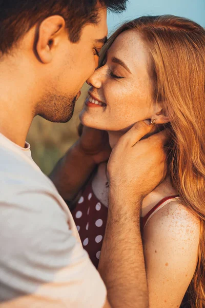 Utomhus porträtt av ett kaukasiskt par poserar samtidigt kyssas i vetefält. En vacker ung flicka. Närbild porträtt. — Stockfoto