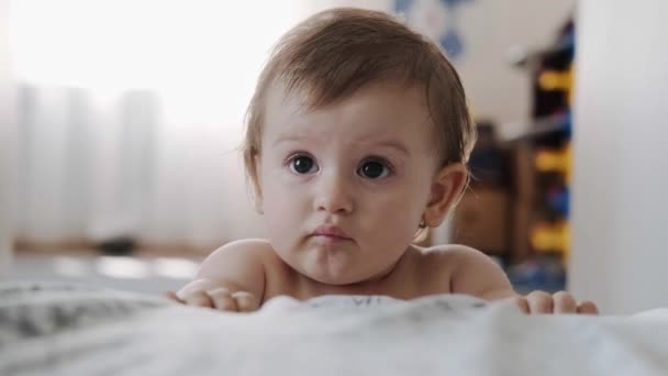 Video bayi berdiri dan bersandar di tempat tidur. Bayi jatuh saat belajar untuk berdiri. — Stok Video
