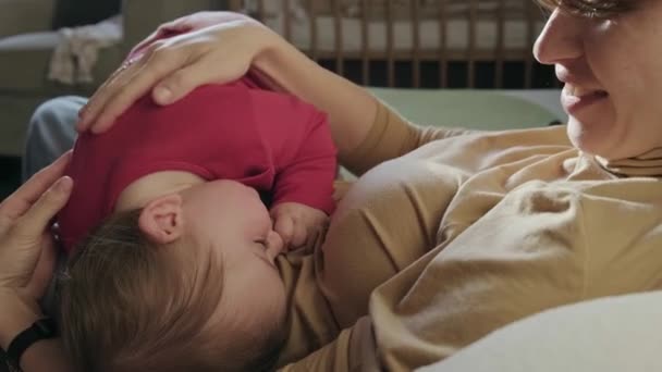 Vidéo avec une mère caresse le bébé alors qu'il essaie de s'endormir dans ses bras. Soins pour bébés. — Video