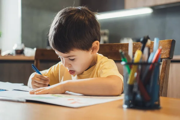 Niño caucásico aprendiendo alfabeto. Chico escribiendo deberes. Estilo de vida cuarentena. —  Fotos de Stock