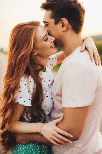 Beau jeune couple caucasien embrassant et souriant tout en se tenant à l'extérieur. Beau paysage d'été. Vacances d'été. — Photo