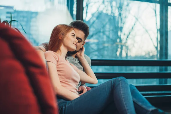 Pareja caucásica en casa abrazándose y besándose en el sofá celebrando el Día de San Valentín. Hermosa persona femenina. — Foto de Stock