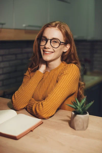 Ritratto di una studentessa dai capelli rossi con gli occhiali che sorride e guarda la macchina fotografica mentre trascorre il suo tempo libero a leggere libri. Ritratto di donna d'affari — Foto Stock