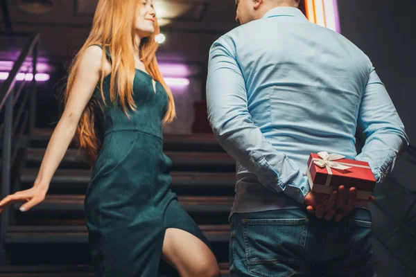 Homme montant les escaliers du restaurant pour rencontrer sa petite amie, se cachant derrière un cadeau d'anniversaire. Pour la conception de célébration. Fête d'anniversaire. — Photo