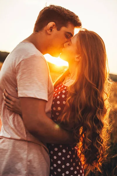 小麦畑でキスをする白人夫婦の側面図。美しい夏の風景。夏休みだ。麦畑. — ストック写真