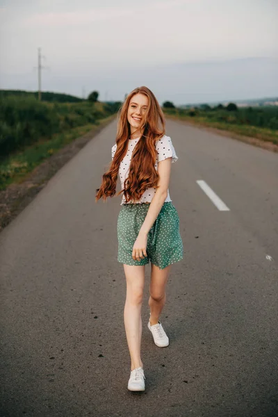 Mujer caucásica posando mientras camina divirtiéndose en un camino fuera de la ciudad. Viaje de libertad. Cara de belleza. —  Fotos de Stock