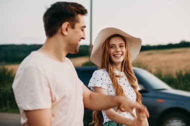 Beyaz bir çift, resimli bir manzara üzerinde yürürken poz veriyor. Kadın erkek modası. Moda portresi..