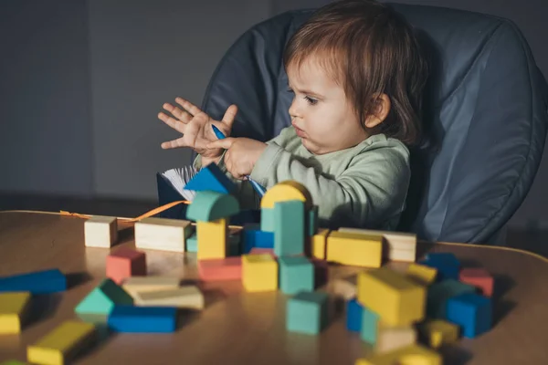 Menina bebê brincando com a conexão de cubos de brinquedo em casa. Educação infantil. Brinquedos de madeira. Os miúdos brincam. Mesa de madeira, mesa. — Fotografia de Stock