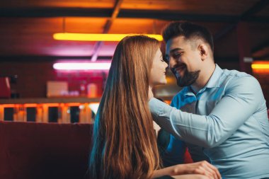 Seçkin bir restoranda kızıl saçlı kız arkadaşıyla öpüşen bir adam. Her amaç için harika bir tasarım. Zarif stil.