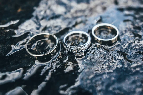 Três Anéis Noivado Com Diamantes Fotografados Pedra Molhada Fundo Natureza — Fotografia de Stock