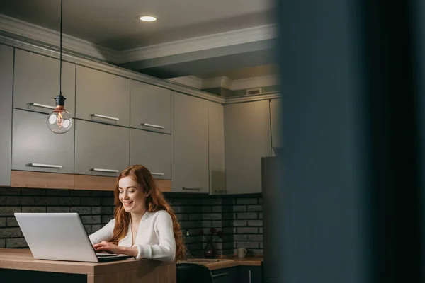Red Haired Woman Working Laptop Kitchen Looking Computer Screen Smiling — Stock Photo, Image