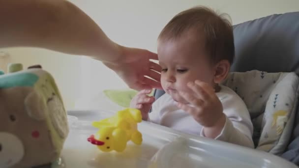 Bebê Pegando Brinquedo Borracha Amarela Mesa Começa Chupá Enquanto Mãe — Vídeo de Stock