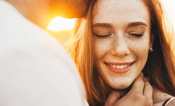 Közelkép egy boldog szeplős lányról, akit a férje homlokon csókolt. Utazási koncepció. Csukd be a képet. Búzamező. — Stock Fotó