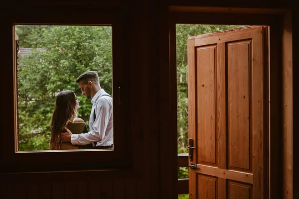 발코니에 서서 서로 다정하게 이야기를 나누며 바라보고 있는 신랑 과 신부 의숙 소 창문에서 바라본다. 말하는 사람들. 아름다운 아가씨. — 스톡 사진