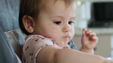 Bebek masadan tatlı böğürtlen alıp yiyor. Öğle yemeği molası. Şirin bir yüz. Güzel portre..