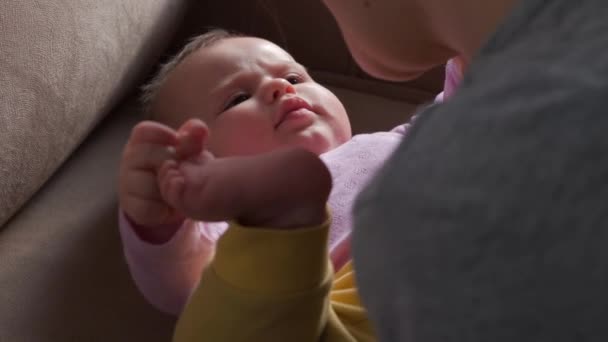 Madre jugando con su lindo bebé acostado en la cama, niño mirando a mamá. Concepto de infancia feliz. Cara feliz. Concepto casero. — Vídeos de Stock