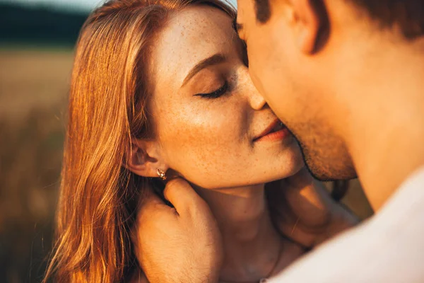 Großaufnahme Porträt eines sommersprossigen Mädchens, das ihren Freund küsst, während sie bei einem Outdoor-Date sind. Weizenfeld. Lebensstil-Konzept der Menschen. — Stockfoto