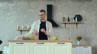 Gözlüklü beyaz adam çevre çantasından taze meyve çıkarıyor. Sağlıklı bir yaşam tarzı. Sağlıklı beslenme. Doğal organik beslenme. Organik yiyecekler.