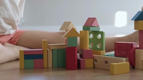 Las manos de los niños destruyen la construcción de cubos de colores. Los niños construyen casa de juguete. Niña enojada. Edificio de arquitectura. Verde, rojo, amarillo. — Vídeos de Stock