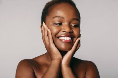 Beyaz arka planda izole edilmiş, dişlek gülümseyen Afro-Amerikan kadın yüzü. Yakın plan portre. Moda tarzı tasarımı için. Güzel bir kadın yüzü.