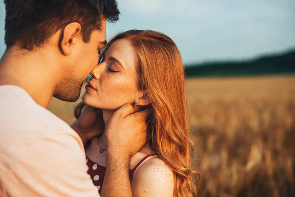 Portrait of a couple kissing standing in wheat field. Beauty, fashion. Wheat field. — Stock Photo, Image