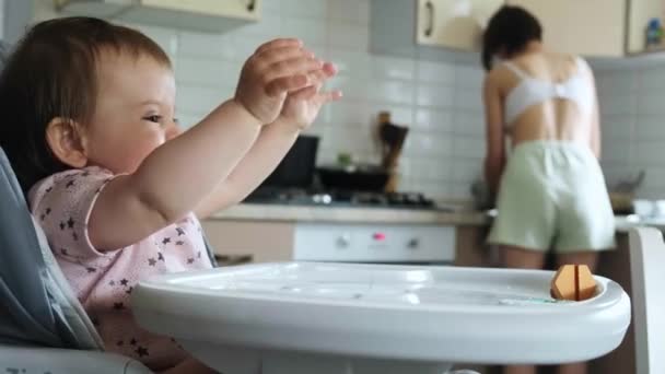 Menina sentada em cadeira alta irritada porque ela não conseguiu comida. Criança zangada. Menina bonita. — Vídeo de Stock