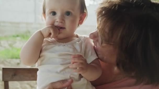 Видео, где бабушка держит племянницу в руке, играет и веселится вместе. Семейный день. Уход за ребенком. — стоковое видео