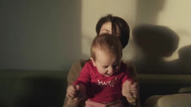 赤ちゃんの女の子と息子の手を握って遊ぶ母親。屋内で遊んでいる母親の子供の肖像画。一緒に幸せな家族. — ストック動画