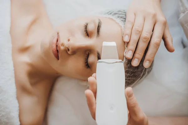 Top view of a caucasian woman getting skin analized by cosmetologists hands, using skin analyzer.edical treatment. Facial treatment. Cosmetology beauty — Stock Photo, Image