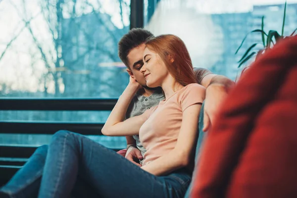 Mujer y hombre guapo disfrutando pasar tiempo juntos sentados en el sofá en la sala de estar. — Foto de Stock