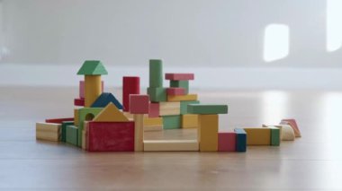 Tahta parçalardan yapılmış ve bir çocuk tarafından yıkılan bir binanın yakın plan portresi. Yaşam tarzı tasarımı için güzel.