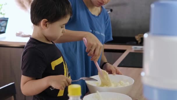 小男孩帮助妈妈准备自制的华夫饼，将面团配料和面粉混合在一起。为生活方式设计。甜食. — 图库视频影像