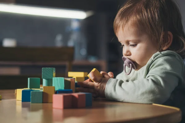 Retrato de uma menina a jogar jogos de desenvolvimento. Bebê brincando com blocos de brinquedo. Desenvolvimento do bebê. — Fotografia de Stock