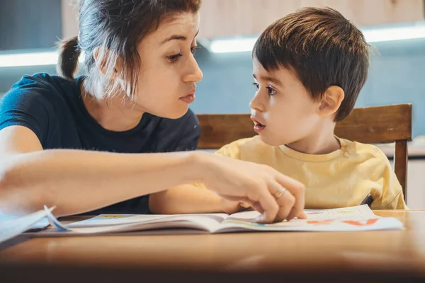 Madre corrigiendo el error cometido por su hijo en las lecciones caseras. Estudiar, hacer los deberes. Enseñanza en línea. Educación en línea. —  Fotos de Stock