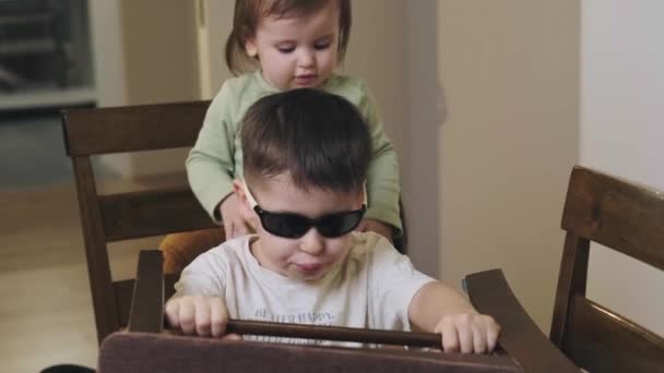 Hijo e hija jugando carreras de coches con sillas en la sala de estar. La familia imagina conducir a casa. Educación infantil. — Vídeos de Stock