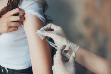 Doktorlar hastaya iğne yapmadan önce ellerinde şırınga ve pamuk tutuyorlar. Aşı kampanyası konsepti. Coronavirus önleme. Koronavirüs salgını