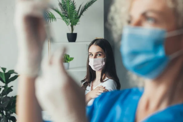 Medico che prepara l'iniezione di vaccinazione con una siringa a una donna spaventata. Siringa per uso medico e persone vaccinate, misure protettive contro il virus — Foto Stock