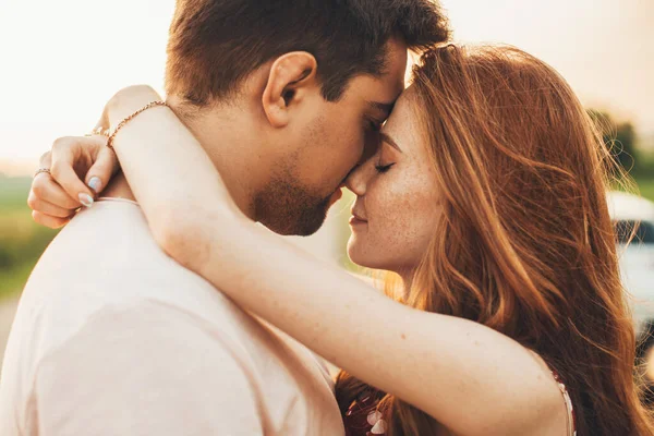 Açık havada birbirine yakın duran neşeli romantik bir çiftin yan görünüm portresi. Güzel bir portre. Yakın plan..