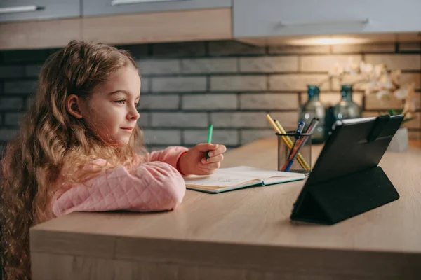 Niña caucásica aprendizaje con tutor en línea en la tableta en casa por la mañana. educación de los niños, aislamiento personal, brote de coronavirus distanciamiento social o —  Fotos de Stock