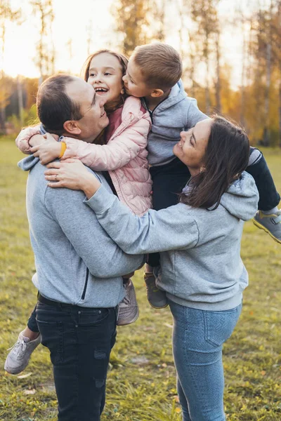 Heureuse famille caucasienne s'amuser en plein air, riant ensemble dans le parc de la ville. Concept d'amour. Souriant enfant heureux. Bonne famille. Jour de famille. — Photo