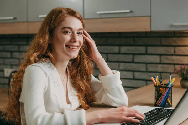 Gülümseyen beyaz kadın portresi evinde oturmuş internete bakıyor ya da internetten iletişim kuruyor. Dizüstü bilgisayarda çalışan kadın. Çevrimiçi iletişim — Stok fotoğraf