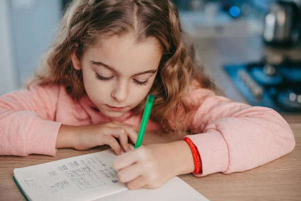 Closeup portrait of a girl writing doing homework, learn from home and practicing write. Beautiful girl. — Stock Photo, Image