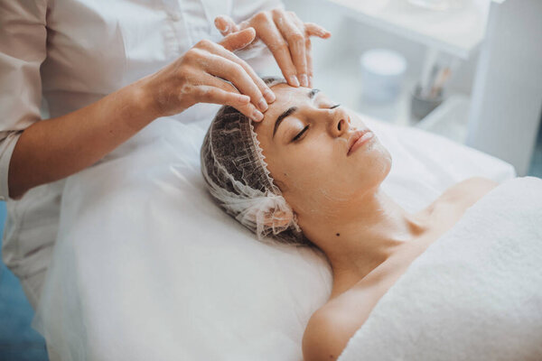 Caucasian woman having a foam face massage at spa salon. Facial skin treatment. Body care. Beauty treatment. Cosmetology beauty procedure. Medical treatment