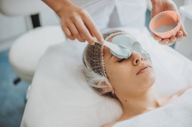 Kadınların yüzü aljinat maskesiyle kaplıyken kaplıcada yüz bakımı yapılıyor. Doğal güzellik konsepti. Sağlık hizmeti konsepti. Cilt bakımı kavramı.