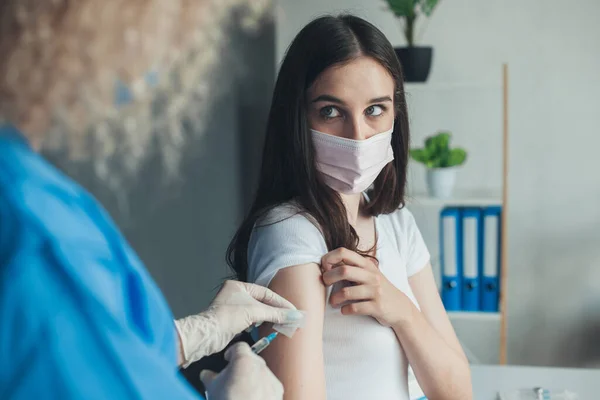 Vista da parte dei medici delle mani posteriori che tengono la siringa e puliscono la pelle sulla parte superiore del braccio prima della vaccinazione. Concetto di antivirus. Il concetto di medicina. Protezione da virus. Medico — Foto Stock